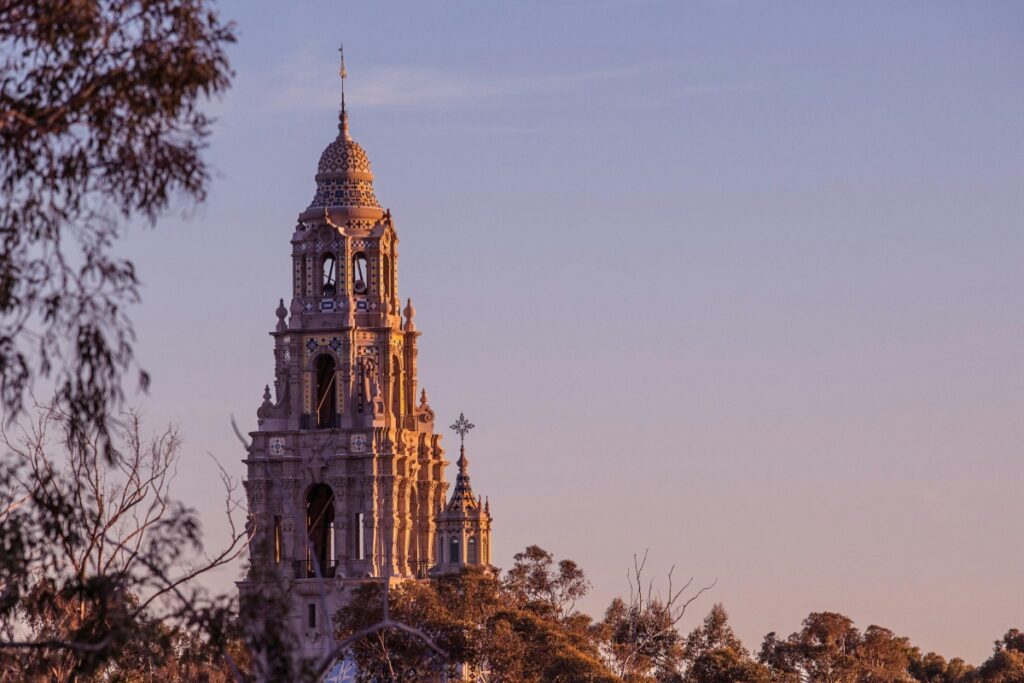Esta imagen muestra una majestuosa torre con un detalle arquitectónico muy elaborado, rodeada de árboles. La torre se ve resaltada con la luz del atardecer. Para empresarios en Chile que deseen atraer tráfico a su negocio online a través de Pinterest, compartiendo imágenes de hermosos monumentos y edificios históricos como esta torre, siguiendo las estrategias de "Pinterest en Chile Atrae Tráfico a Tu Negocio Online", pueden captar la atención de usuarios interesados en arquitectura y cultura, y así, aumentar la visibilidad de su negocio digital.