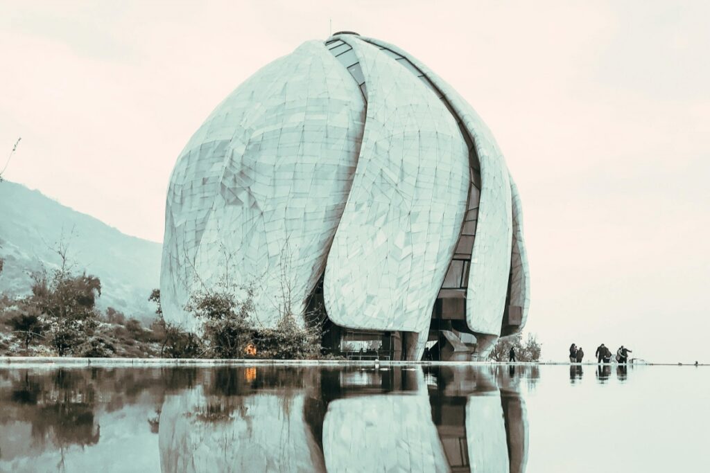 Esta imagen presenta un moderno edificio de forma esférica y sinuosa, con una textura de placas que lo hace muy atractivo visualmente. Está rodeado de una superficie de agua que refleja el edificio, y se ven algunas personas cerca. Para las marcas en Chile en 2025, Snapchat puede ser una herramienta útil. Compartiendo contenido de lugares modernos e interesantes como este a través de Snapchat, siguiendo las estrategias que responden a la pregunta "Snapchat en Chile ¿Es útil para tu marca en 2025", se puede alcanzar a un público joven y activo, aumentando la visibilidad y la interacción con la marca.