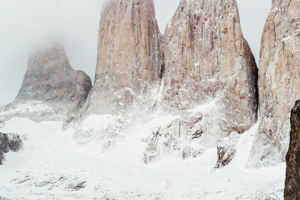 Esta imagen muestra impresionantes picos de roca cubiertos de nieve, probablemente en una región montañosa de Chile. Las majestuosas formaciones rocosas y la capa blanca de nieve crean un paisaje épico. Para empresarios en Chile que buscan aumentar sus ventas a través de WhatsApp Business, promocionando experiences turísticas o productos relacionados con la naturaleza y la montaña en lugares como este, siguiendo las estrategias de "WhatsApp Business Cómo Vender Más en Chile", puede ser una forma efectiva de alcanzar un público interesado.